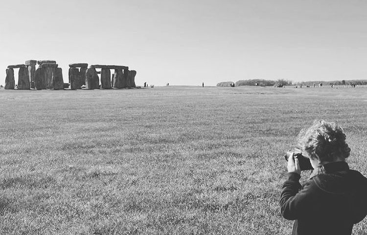A child at Stonehenge taking a picture of the stone circle